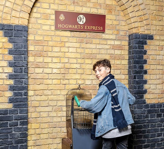 Tourist pushing trolley at Platform 9¾, Harry Potter set, London.