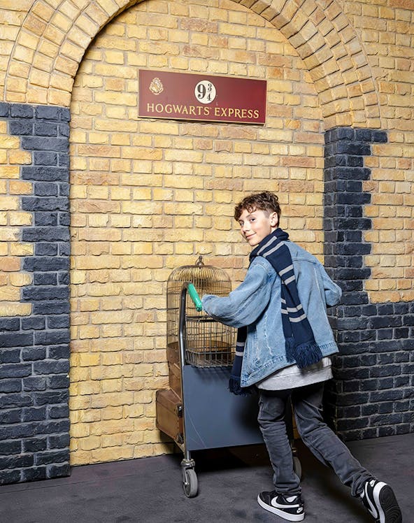 Tourist pushing trolley at Platform 9¾, Harry Potter set, London.