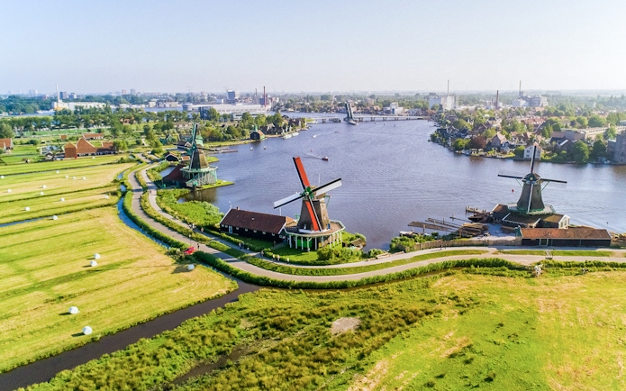 Aerial view of Zaanse Schans windmills by the river near Amsterdam.