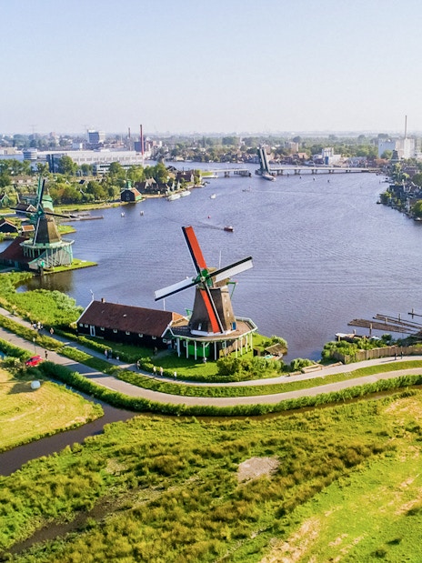 Aerial view of Zaanse Schans windmills by the river near Amsterdam.