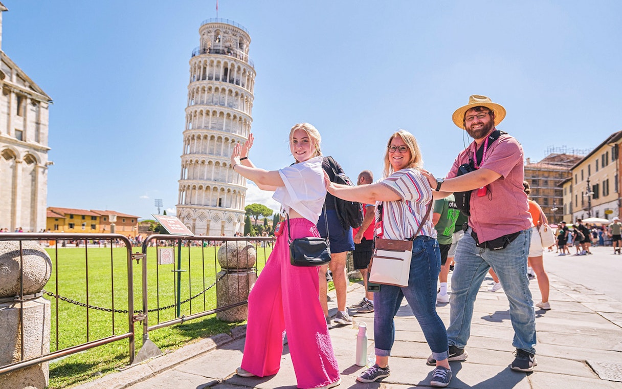 Visitors posing creatively with the Leaning Tower of Pisa in Italy.