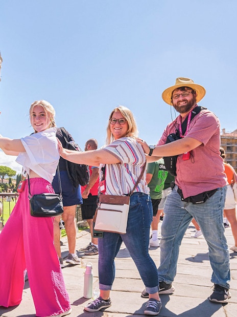 Visitors posing creatively with the Leaning Tower of Pisa in Italy.
