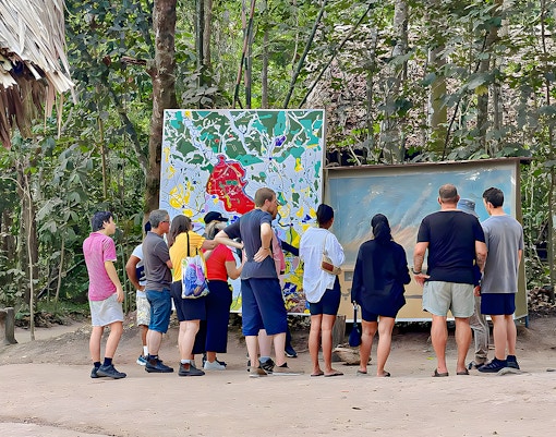 Tour group examining maps at Cu Chi Tunnels, Vietnam.