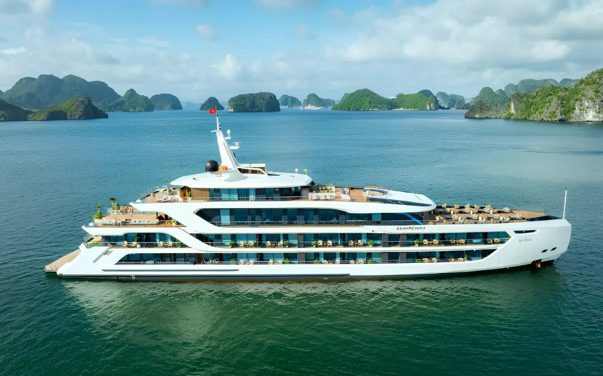 Luxury cruise ship in Ha Long Bay with limestone islands in the background.