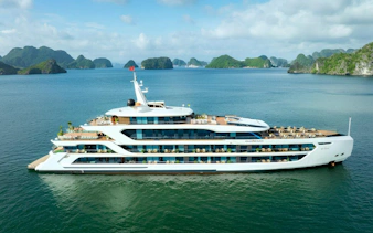 Luxury cruise ship in Ha Long Bay with limestone islands in the background.