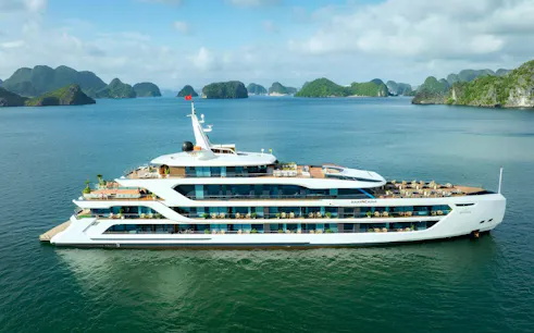 Luxury cruise ship in Ha Long Bay with limestone islands in the background.