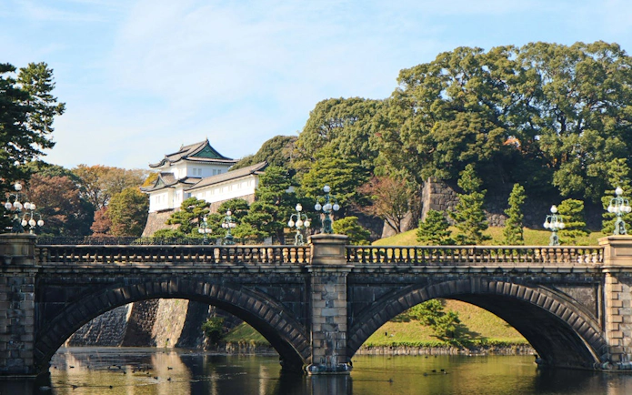 Tokyo Imperial Palace East Gardens with stone bridge and lush greenery.