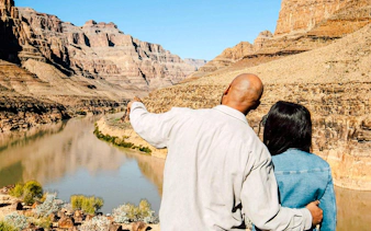 Couple overlooking Grand Canyon from helicopter landing spot, Las Vegas tour.
