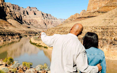 Couple overlooking Grand Canyon from helicopter landing spot, Las Vegas tour.