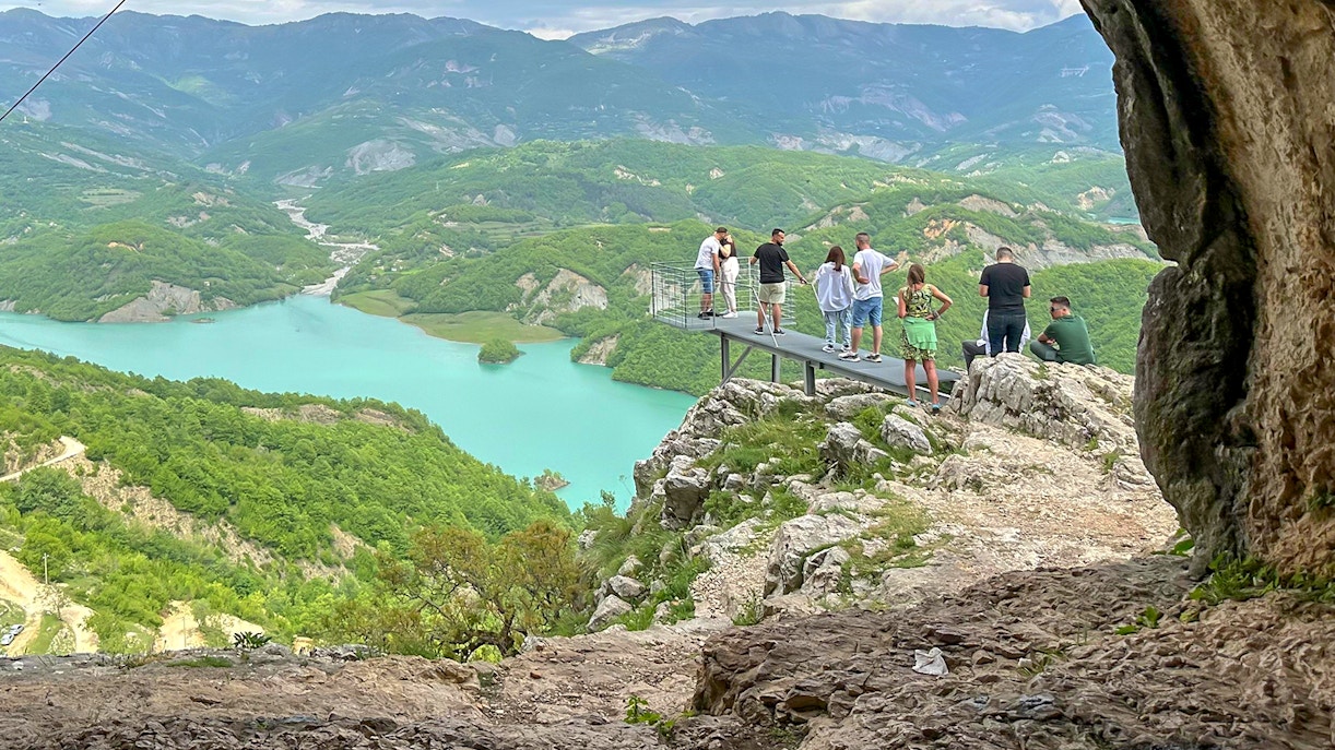 Guests on a platform overlooking Bovilla Lake surrounded by lush mountains.