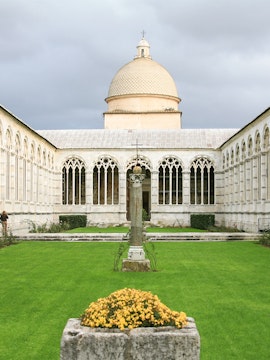 Camposanto Monumentale courtyard with central cross and dome in Pisa, Italy.