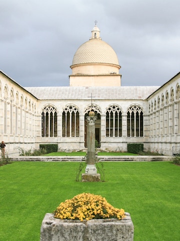 Camposanto Monumentale courtyard with central cross and dome in Pisa, Italy.