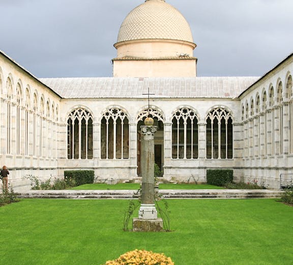Camposanto Monumentale courtyard with central cross and dome in Pisa, Italy.