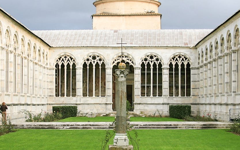 Camposanto Monumentale courtyard with central cross and dome in Pisa, Italy.
