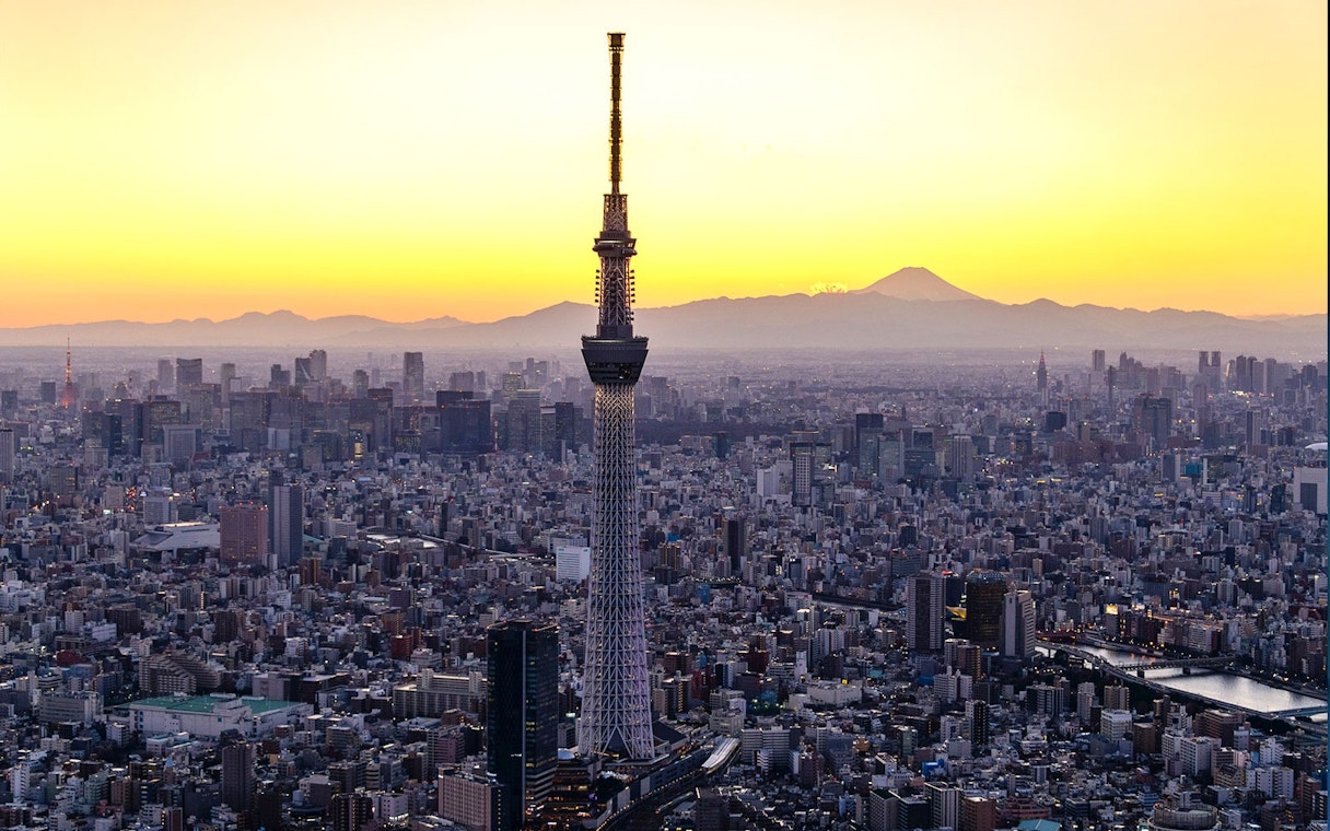 Tokyo Skytree at sunset with cityscape and Mount Fuji in the background.