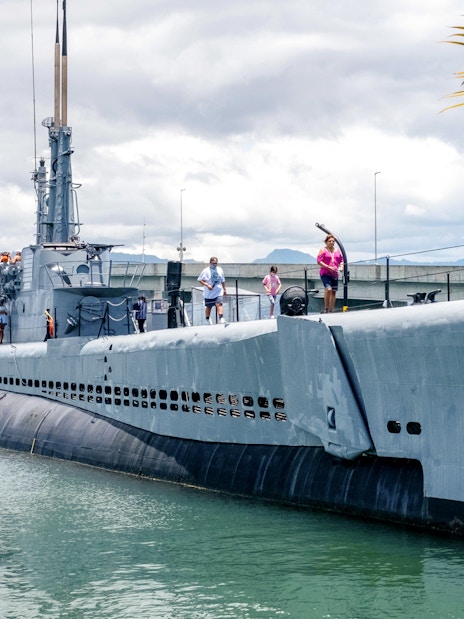 Visitors exploring a Pacific Fleet submarine docked at Pearl Harbor.