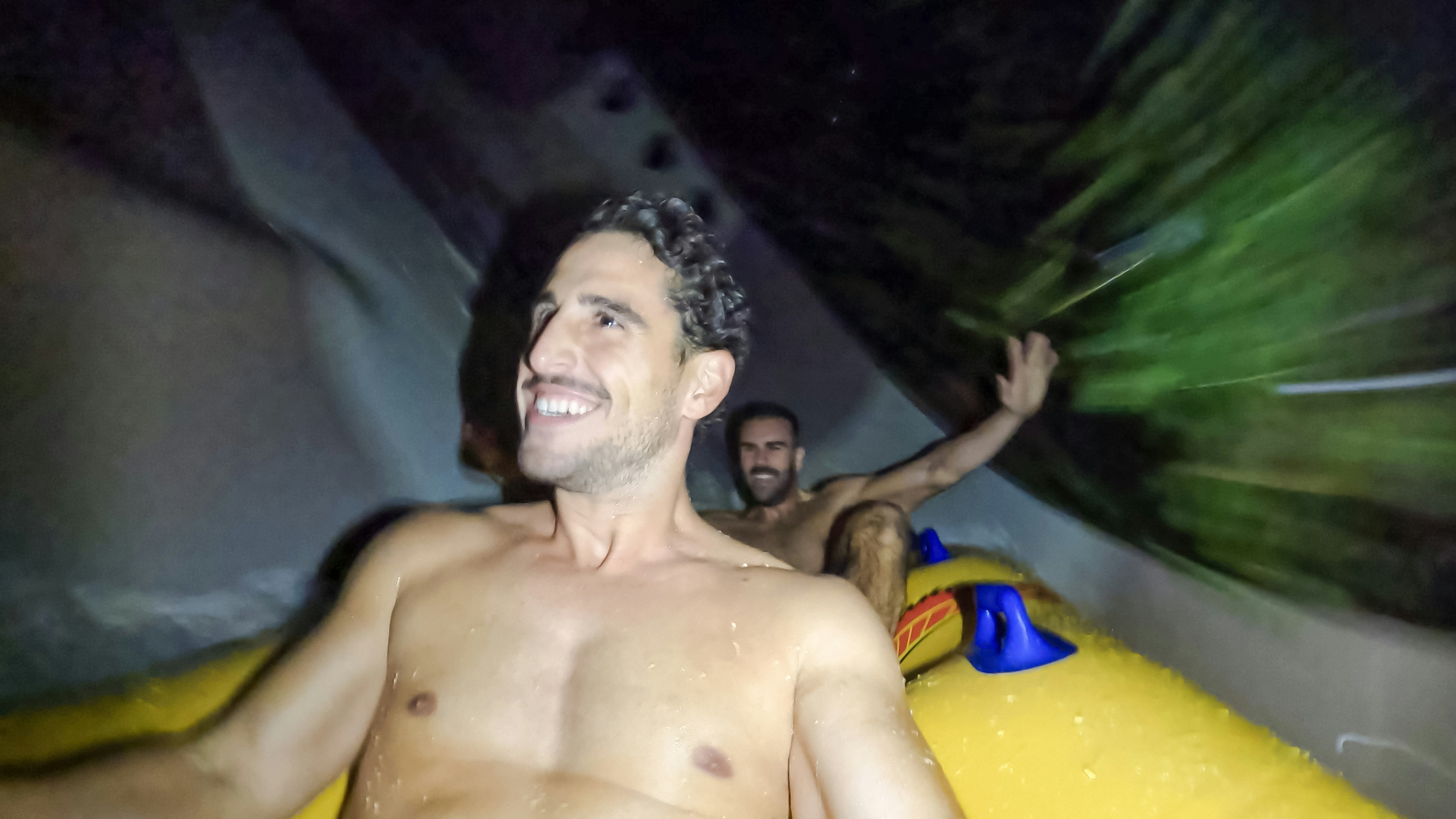 tourists enjoying water park slide at night