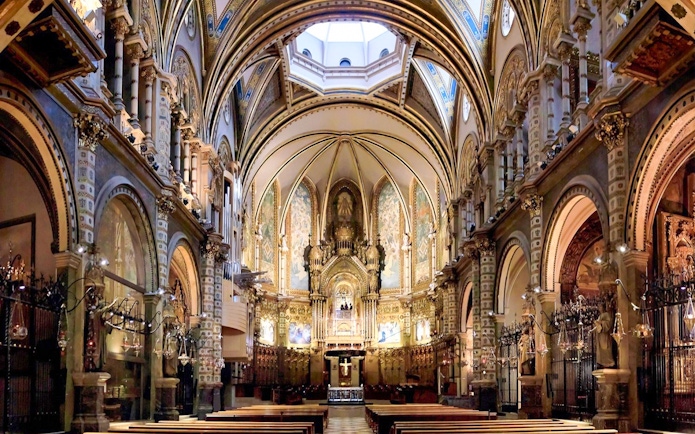 Interior of Montserrat Monastery's basilica with ornate arches and altar, part of Barcelona day trip.