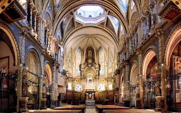 Interior of Montserrat Monastery's basilica with ornate arches and altar, part of Barcelona day trip.