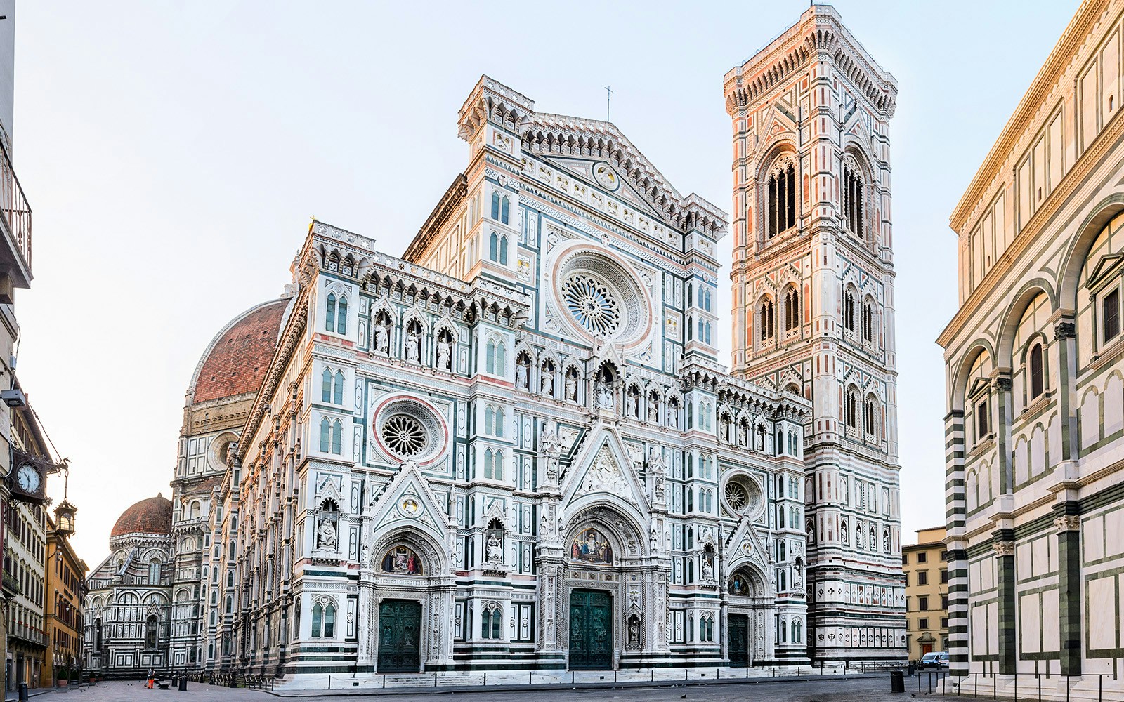 Florence Cathedral with marble façade and bell tower in morning light, Italy.