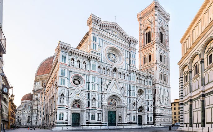 Florence Cathedral with marble façade and bell tower in morning light, Italy.