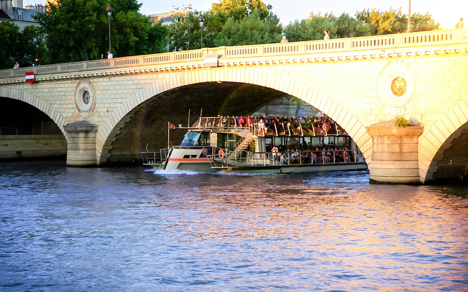 Seine River Cruise boat passing by the Eiffel Tower in Paris, France.