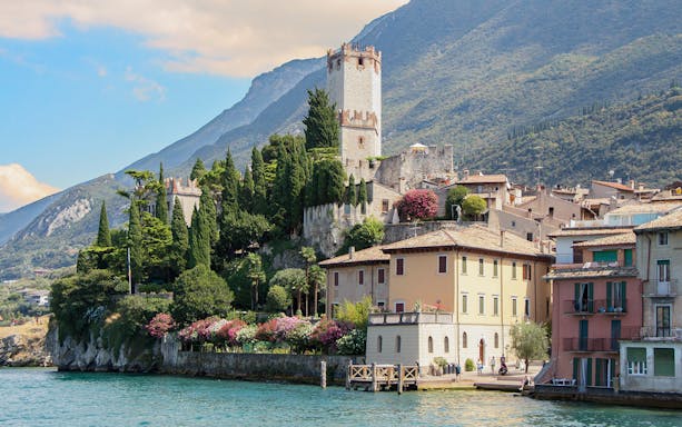 Medieval castle and village on Lake Garda shoreline, Italy.