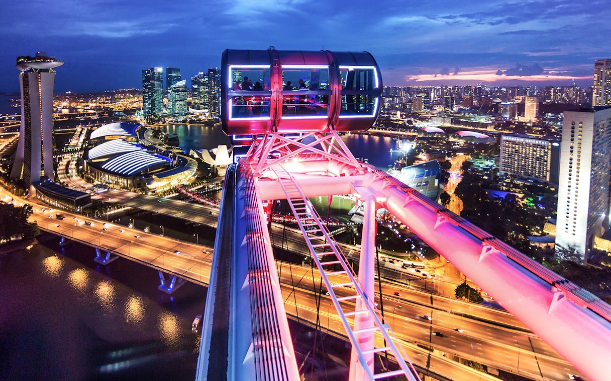 Singapore Flyer cabin illuminated for New Year's Eve, overlooking city skyline.