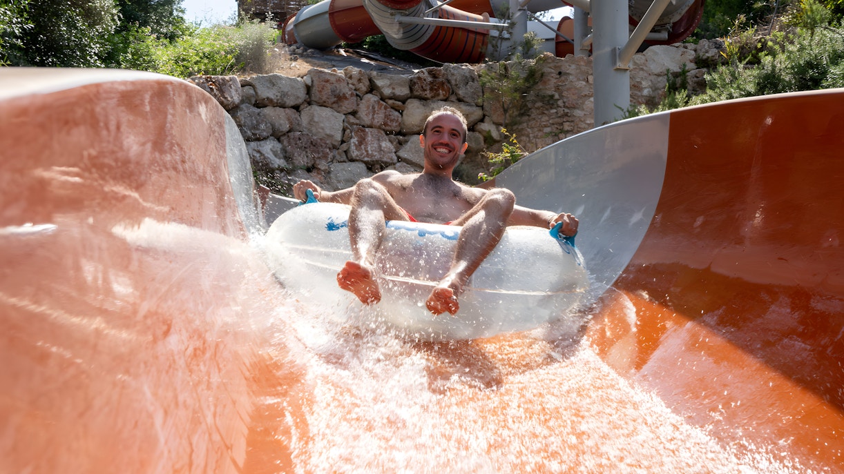 Person enjoying the Calypso slide at Aquopolis Cullera water park.
