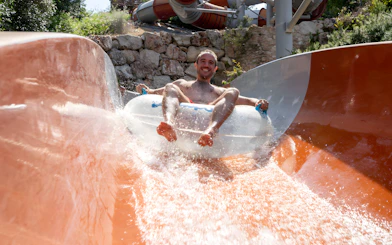 Person enjoying the Calypso slide at Aquopolis Cullera water park.