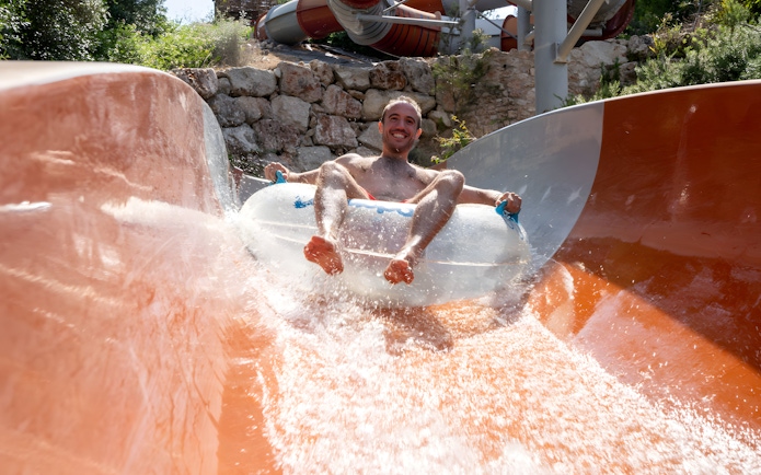 Person enjoying the Calypso slide at Aquopolis Cullera water park.