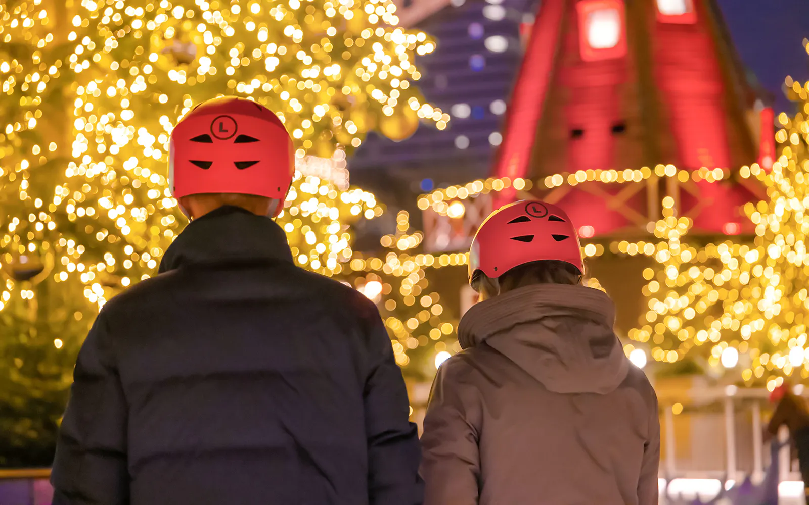 Visitors wearing helmets admire Christmas lights at Tivoli Gardens, Copenhagen.
