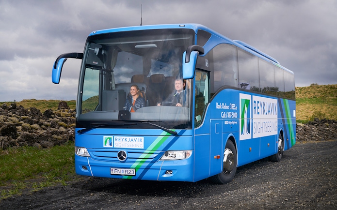 Reykjavik sightseeing bus on Golden Circle tour route with passengers.