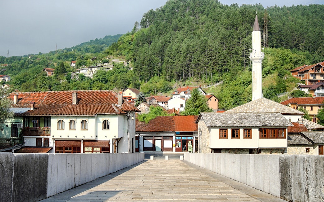 Stone bridge leading to traditional buildings and mosque in Konjic town, Bosnia and Herzegovina.