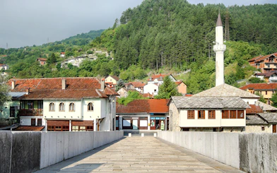 Stone bridge leading to traditional buildings and mosque in Konjic town, Bosnia and Herzegovina.