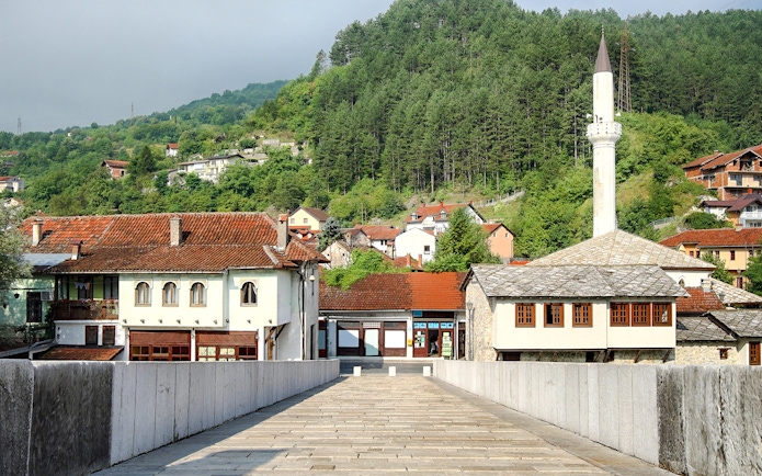 Stone bridge leading to traditional buildings and mosque in Konjic town, Bosnia and Herzegovina.