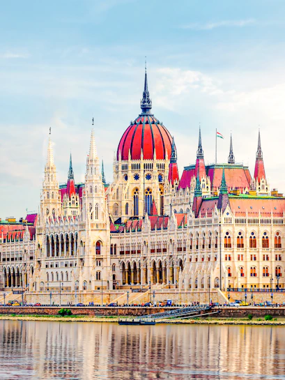 Hungarian Parliament building with red dome by the Danube River in Budapest.