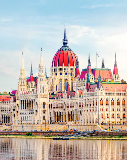 Hungarian Parliament building with red dome by the Danube River in Budapest.