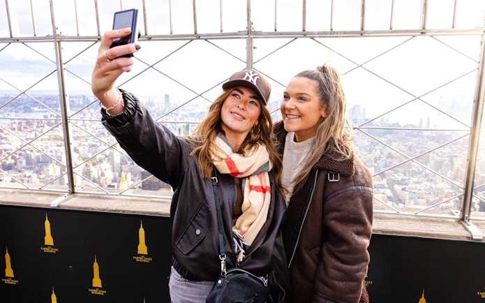 Guests taking a selfie at the Empire State Building observation deck, New York City.