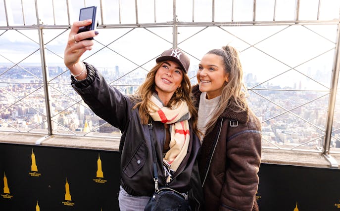 Guests taking a selfie at the Empire State Building observation deck, New York City.