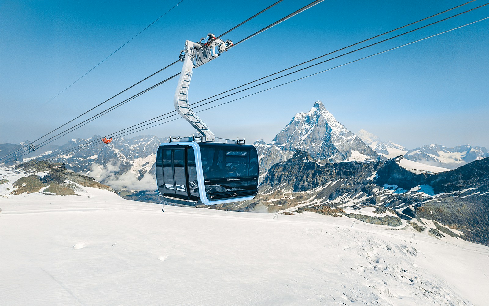 Cable car ascending Matterhorn Glacier Paradise with snowy mountain backdrop.