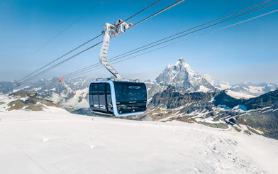 Cable car ascending Matterhorn Glacier Paradise with snowy mountain backdrop.