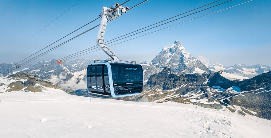 Cable car ascending Matterhorn Glacier Paradise with snowy mountain backdrop.