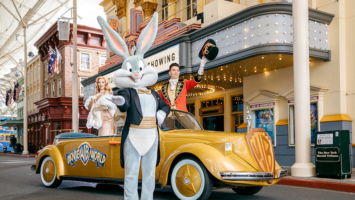 Warner Bros. Movie World parade featuring costumed characters and themed floats.