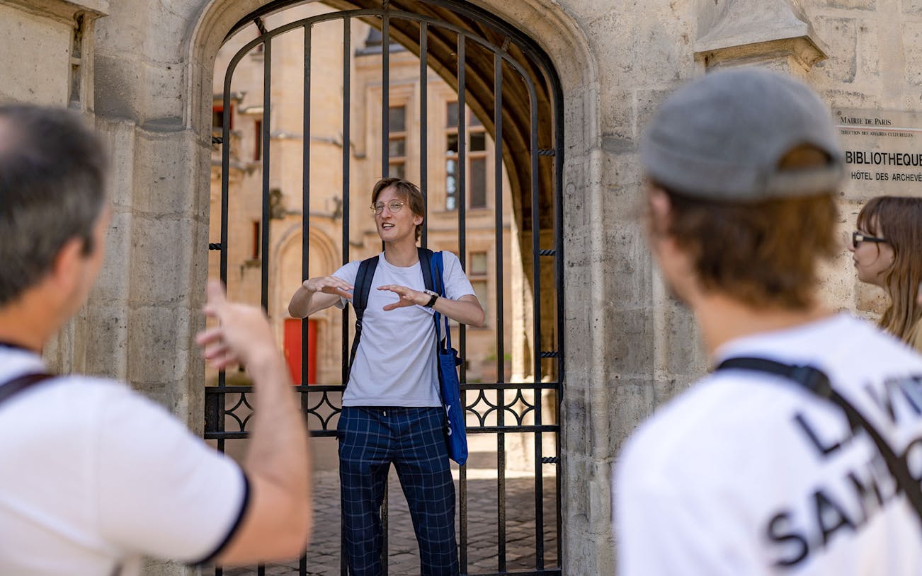 Tour guide explaining historical site during Marais walking tour in Paris.