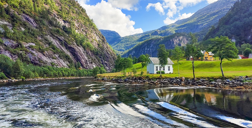 Cruise through Mostraumen Fjord near Bergen, Norway, with scenic mountains and houses.