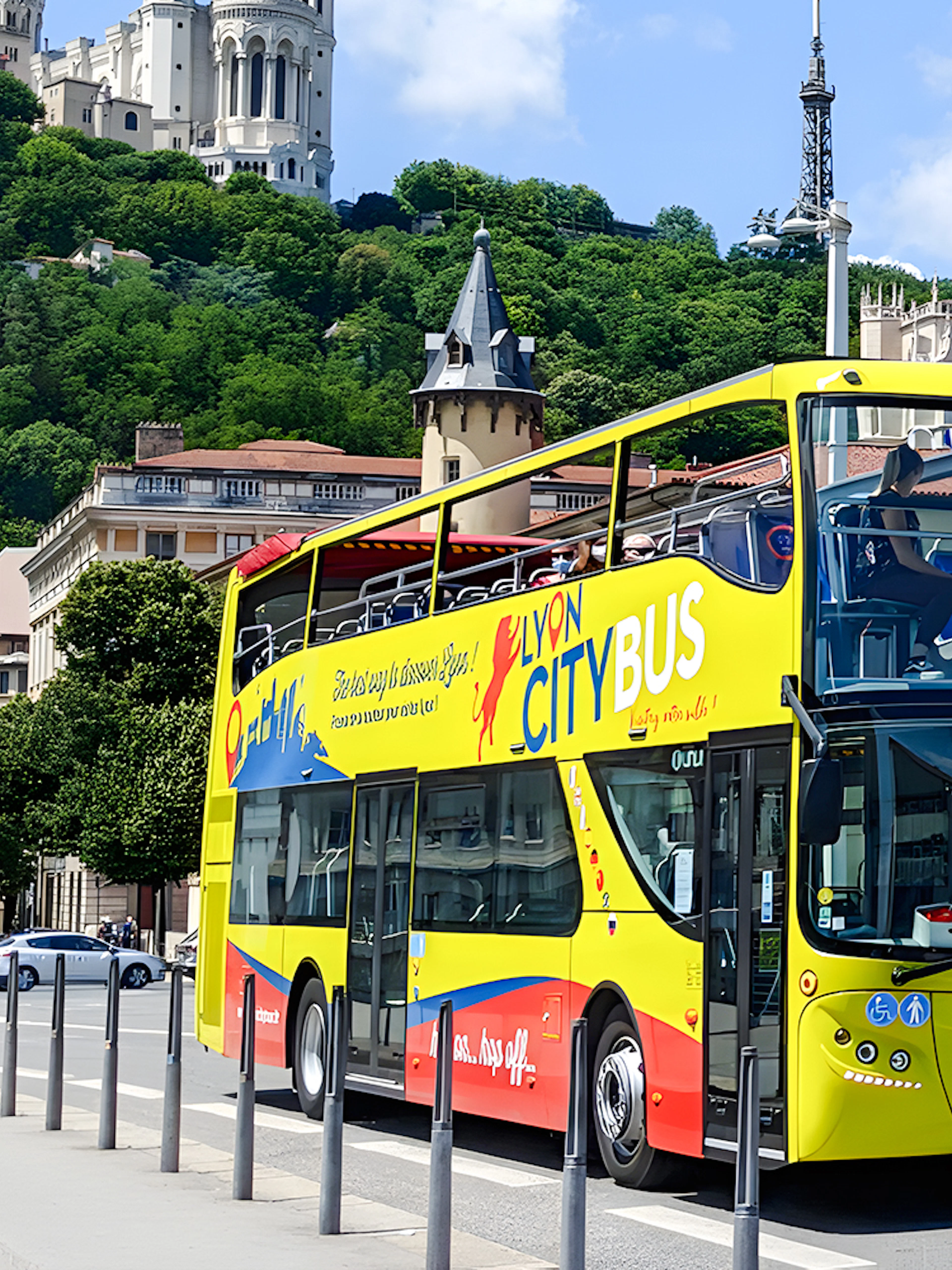 Lyon city tour bus in front of Basilica of Notre-Dame de Fourvière, France.