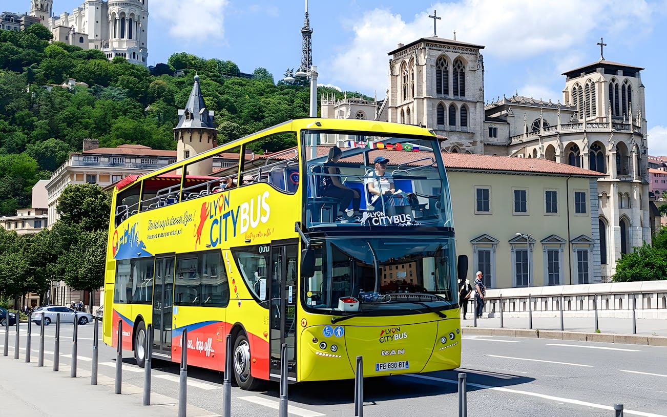 Lyon city tour bus in front of Basilica of Notre-Dame de Fourvière, France.