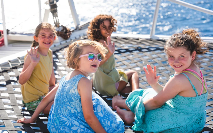 Children enjoying a sail on a catamaran near Waikiki and Diamond Head.