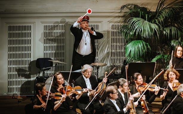 Vienna Hofburg Orchestra performing with conductor and musicians playing violins.